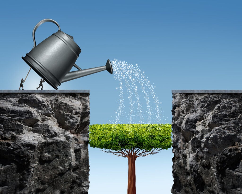 Illustration of two people tilting a large watering can to nourish a tree growing between two rocky cliffs under a clear blue sky.