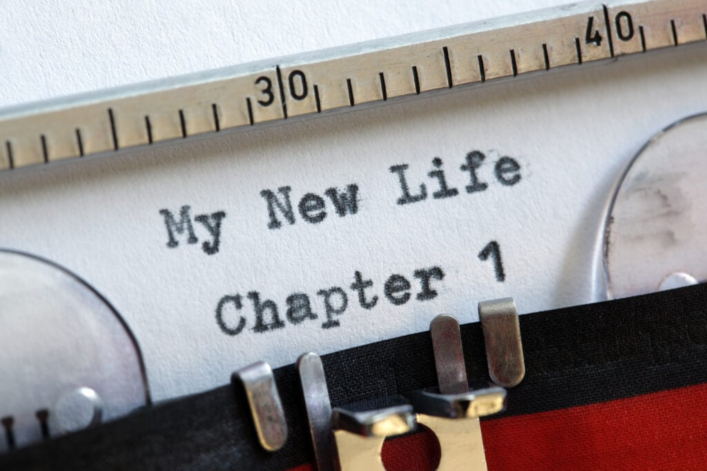 Close-up of a typewriter with paper showing the typed words "My New Life Chapter 1.