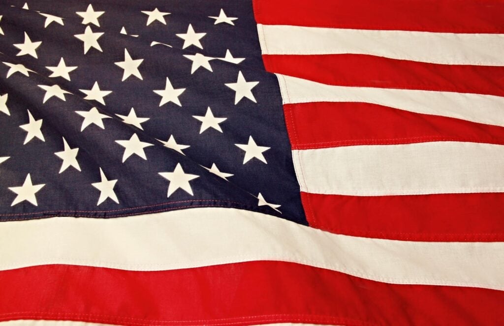 Close-up of a waving United States flag showing stars on a blue field and red and white stripes.
